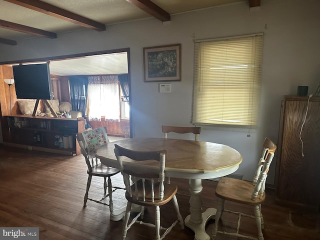 dining room with dark wood finished floors and beam ceiling