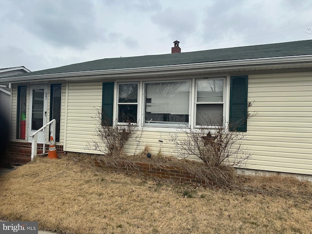 exterior space with entry steps and a front yard