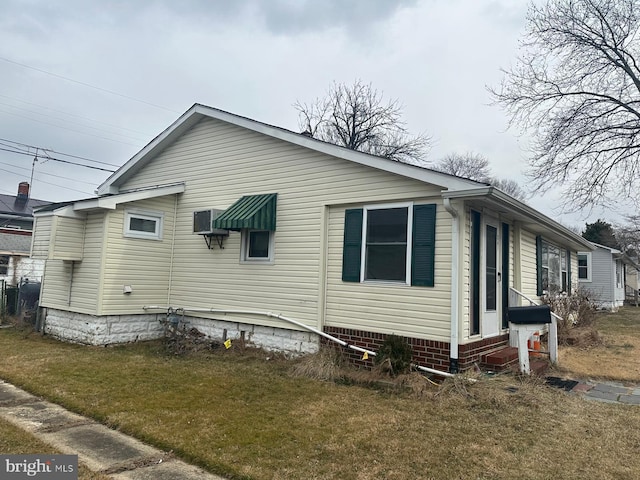 view of side of home with entry steps and a yard