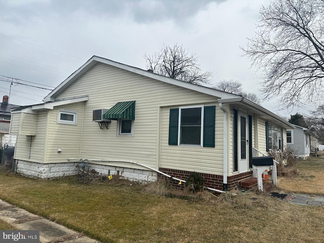 view of side of home featuring entry steps and a yard