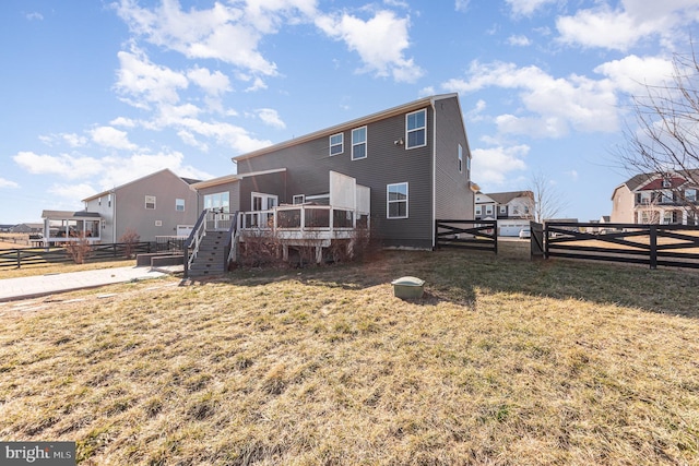 back of property with stairs, fence, a lawn, and a wooden deck