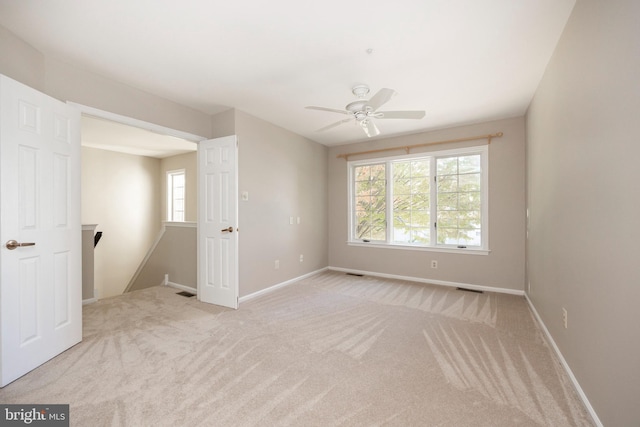 unfurnished room featuring light colored carpet and ceiling fan