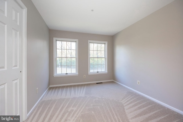 spare room featuring light carpet