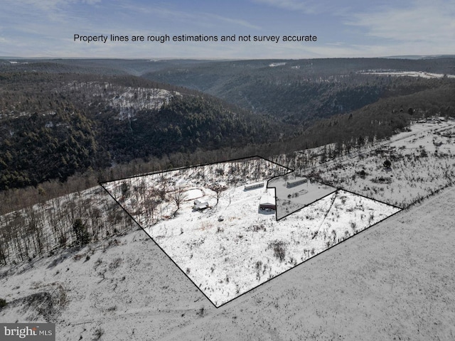 snowy aerial view featuring a mountain view