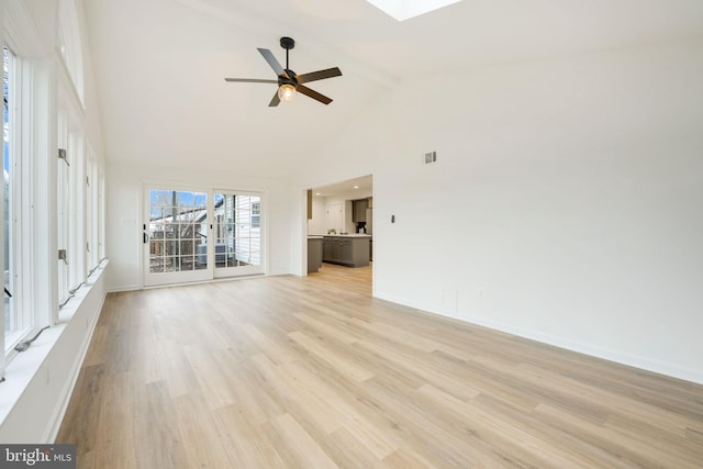 unfurnished living room featuring high vaulted ceiling, a skylight, visible vents, light wood-style floors, and beamed ceiling