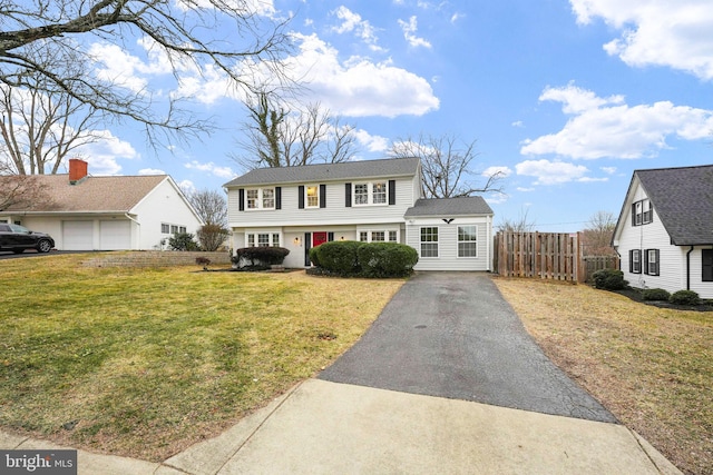 colonial inspired home featuring a front lawn and fence