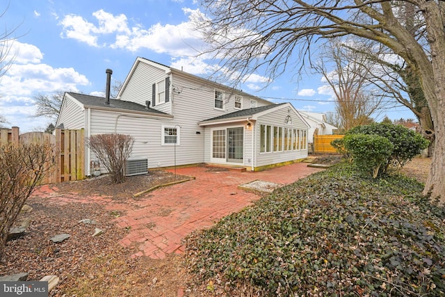 rear view of house with a patio area, fence, and central AC