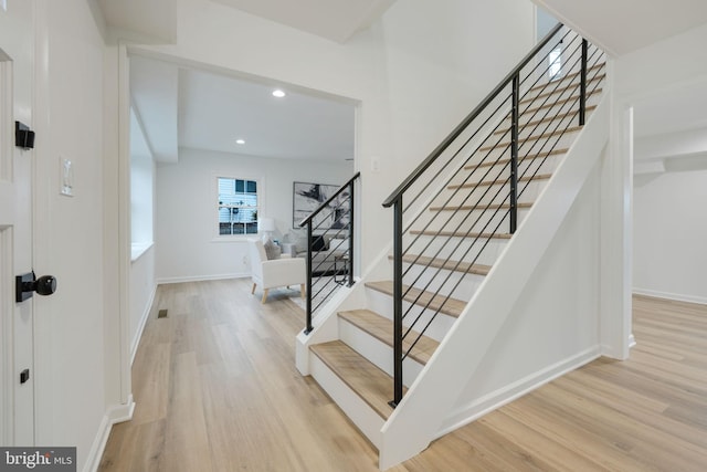 foyer entrance featuring light wood-type flooring, stairs, baseboards, and recessed lighting