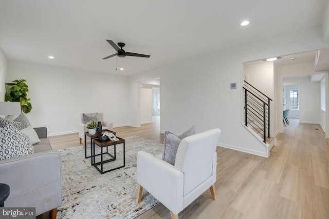 living room with baseboards, light wood-style flooring, ceiling fan, stairway, and recessed lighting