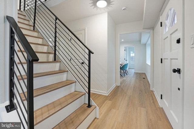 entrance foyer featuring baseboards, stairway, and light wood-style flooring