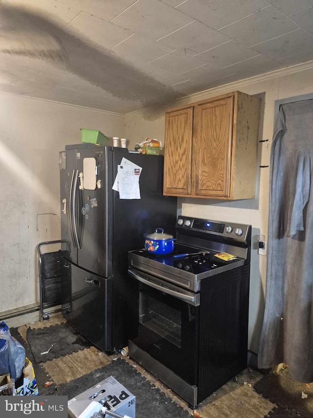 kitchen featuring black refrigerator, ornamental molding, and stainless steel electric range oven