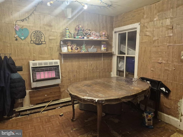 dining area with heating unit, a fireplace, wooden walls, and parquet floors