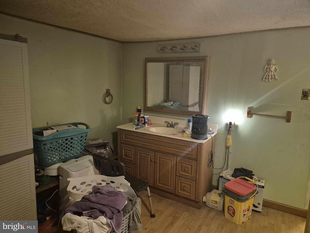 bathroom with hardwood / wood-style flooring, vanity, and a textured ceiling