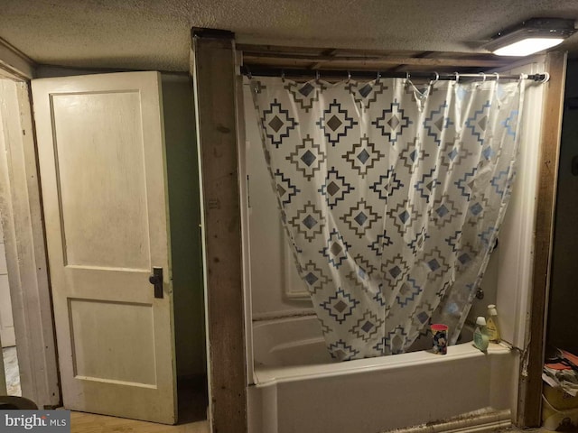 bathroom with shower / bath combination with curtain and a textured ceiling