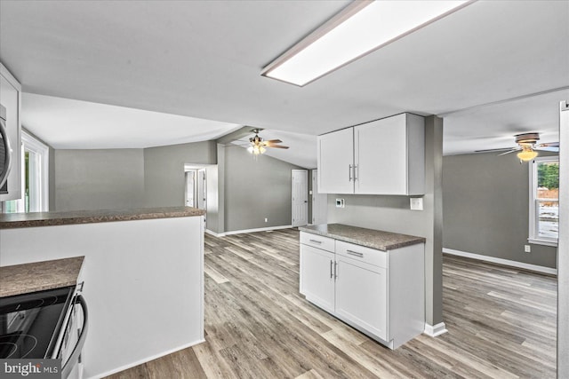 kitchen featuring ceiling fan, lofted ceiling, light wood-type flooring, and white cabinets