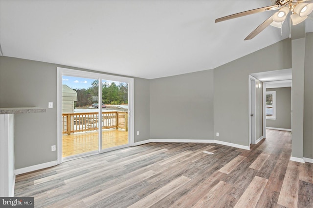 empty room featuring vaulted ceiling, light hardwood / wood-style floors, and floor to ceiling windows