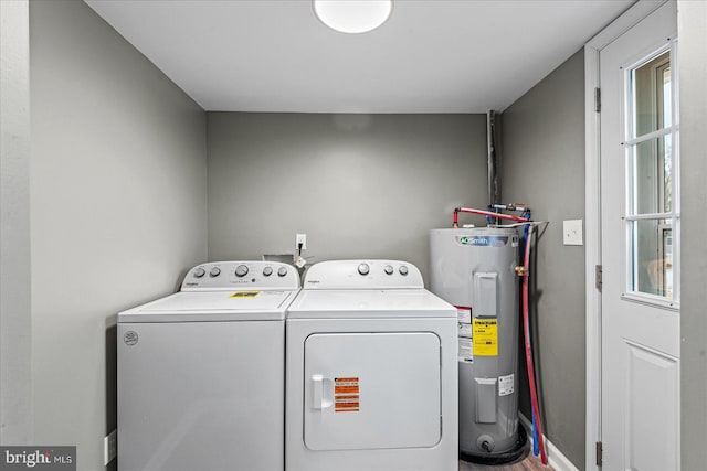 washroom with washing machine and clothes dryer and electric water heater