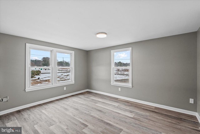 spare room with light hardwood / wood-style flooring and plenty of natural light