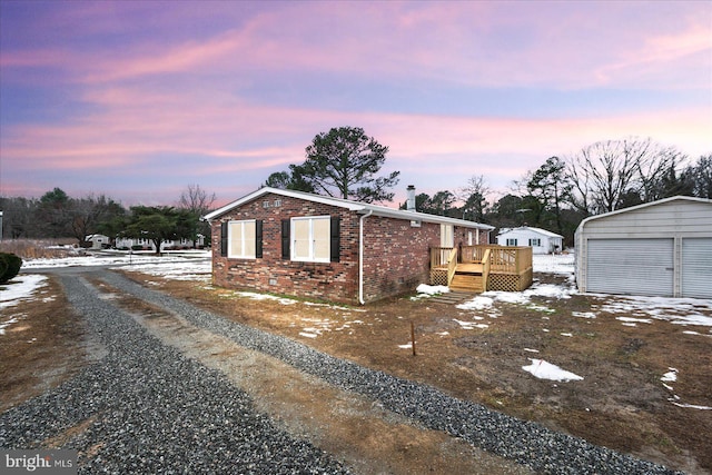 property exterior at dusk with a wooden deck, a garage, and an outdoor structure