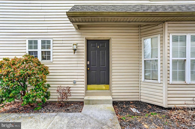 property entrance featuring roof with shingles