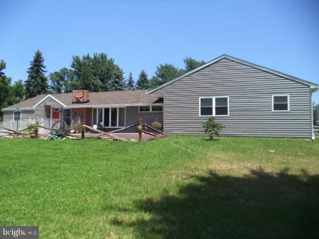 rear view of property with a lawn