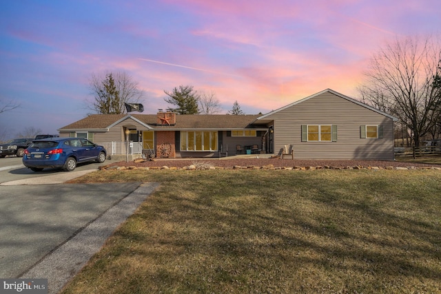 single story home with a lawn