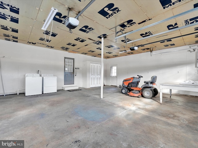 garage with separate washer and dryer and a garage door opener