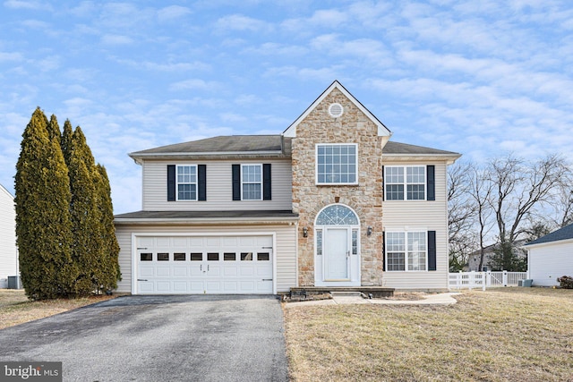 view of front property with a garage, a front yard, and central AC unit