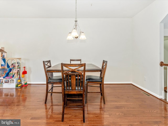 dining room with hardwood / wood-style flooring and a notable chandelier