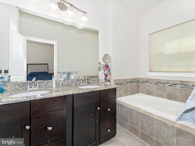 bathroom with tile patterned flooring, vanity, and a relaxing tiled tub