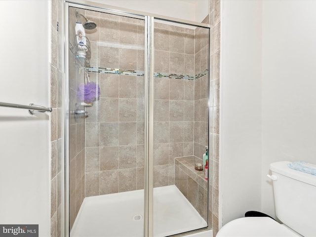 bathroom featuring an enclosed shower and toilet