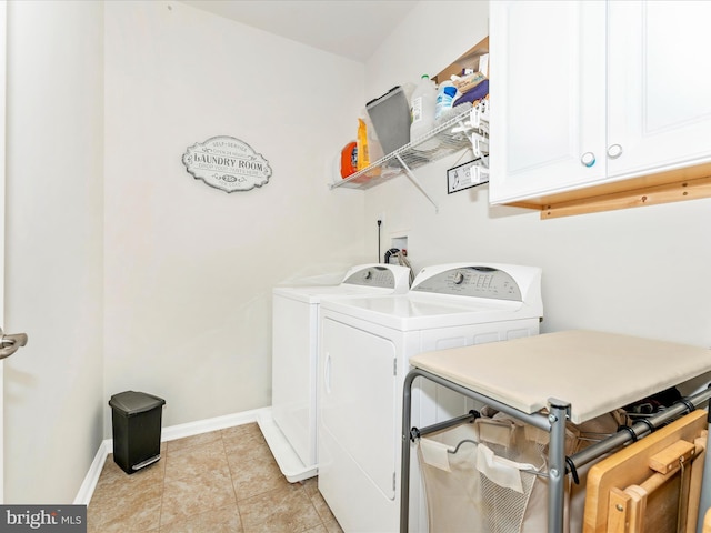 washroom featuring light tile patterned floors, washer and clothes dryer, and cabinets