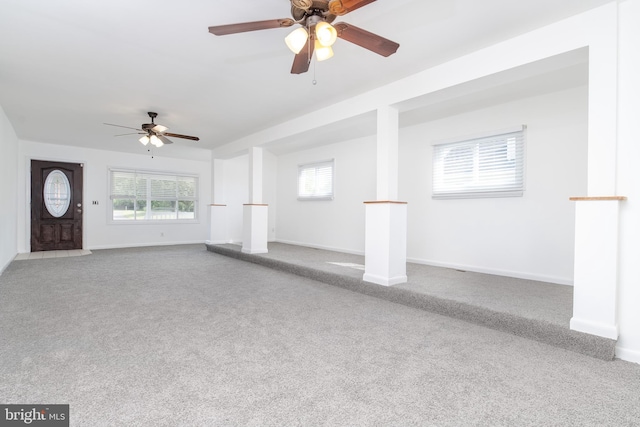 unfurnished living room with ceiling fan, a healthy amount of sunlight, and carpet flooring