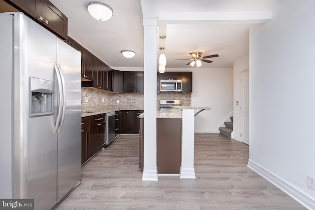 kitchen featuring tasteful backsplash, stainless steel appliances, light stone countertops, dark brown cabinets, and light wood-type flooring