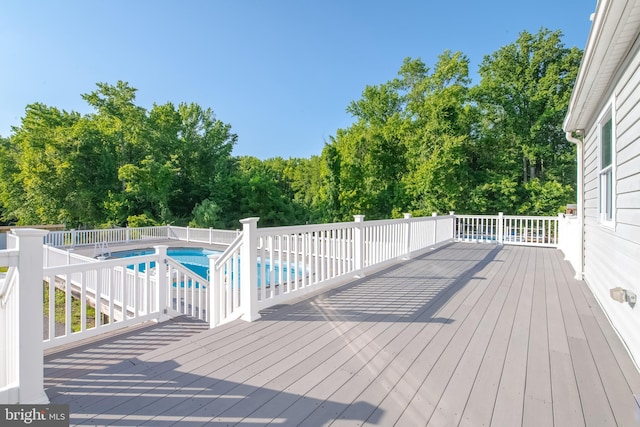 wooden deck with a fenced in pool