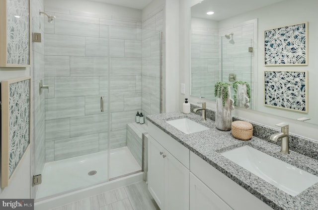 bathroom with a shower with door and vanity