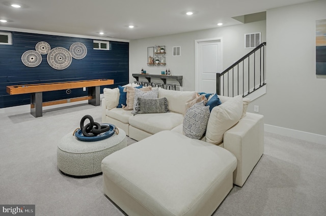 living room with wooden walls and light carpet