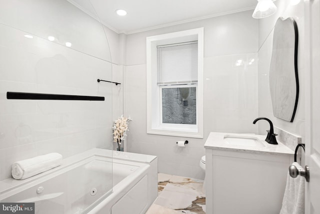 bathroom with toilet, crown molding, tile walls, vanity, and a bathtub