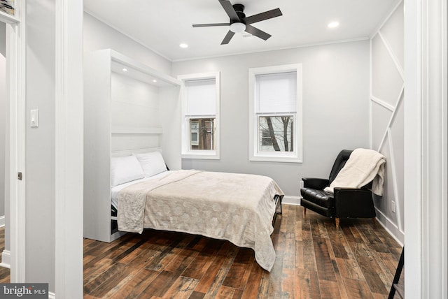 bedroom with crown molding, ceiling fan, and dark hardwood / wood-style flooring