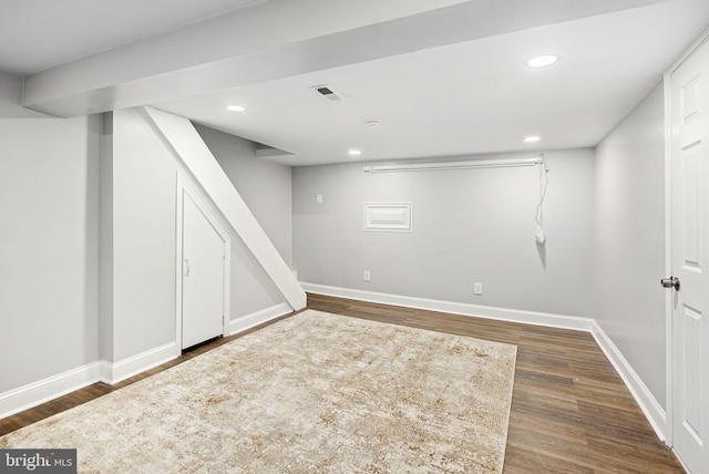 basement with dark hardwood / wood-style flooring