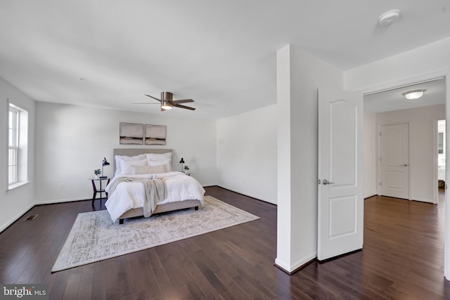 bedroom with baseboards, visible vents, ceiling fan, and dark wood-style flooring