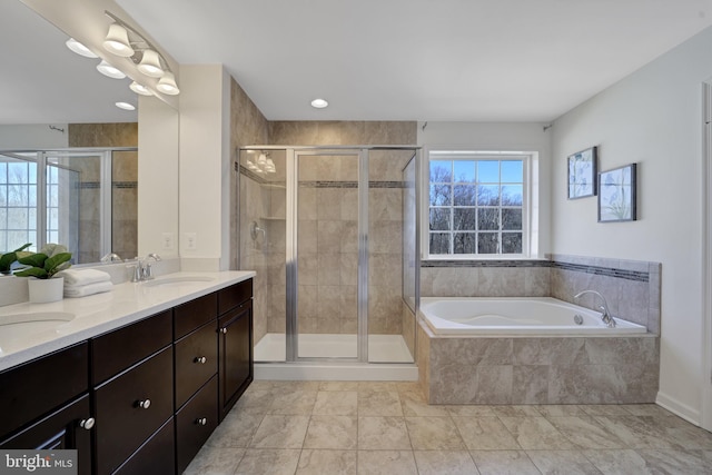 bathroom featuring a garden tub, double vanity, a sink, and a shower stall