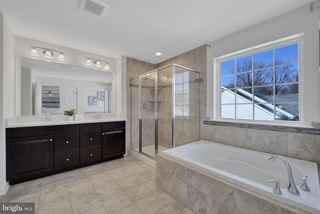 bathroom with a sink, visible vents, a shower stall, a bath, and double vanity