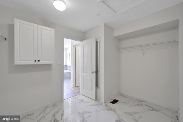 interior space featuring marble finish floor and baseboards