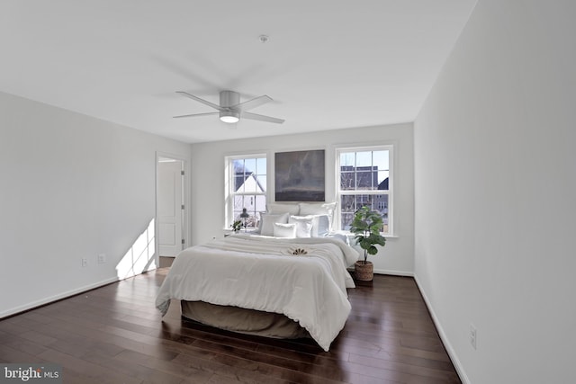 bedroom with dark wood finished floors, a ceiling fan, and baseboards