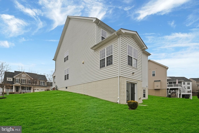 view of side of home with a residential view, brick siding, and a lawn