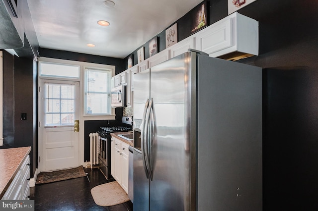 kitchen with stainless steel appliances, dark wood finished floors, light countertops, and white cabinetry