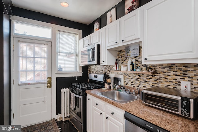 kitchen with white cabinetry, appliances with stainless steel finishes, light countertops, and a sink