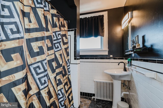 bathroom with a wainscoted wall, radiator heating unit, tile walls, and a shower with shower curtain