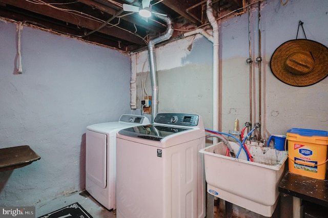 clothes washing area with laundry area, washer and clothes dryer, and a sink